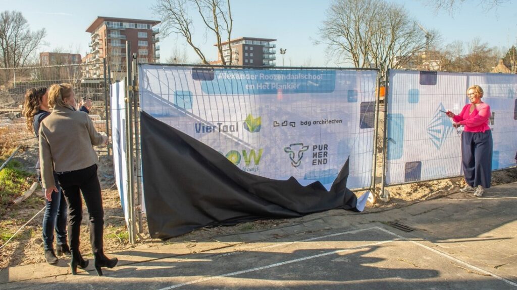 Wethouder (Natalie Saaf) onthult het bouwbord van het nieuwe schoolgebouw aan de Mercuriusweg